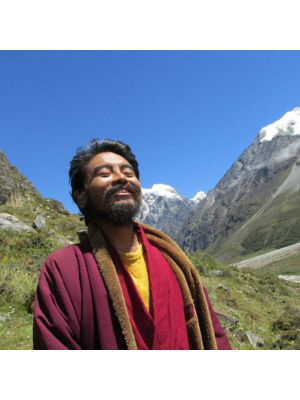 Mingyur Rinpoche während seines Wander-Retreats 2015, lachend in der Sonne mit geschlossenen Augen, im Hintergrund Berge mit schneebedeckte Gipfeln