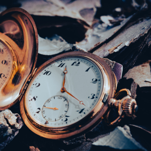 Nahaufnahme einer Taschenuhr, die auf dem Boden liegt