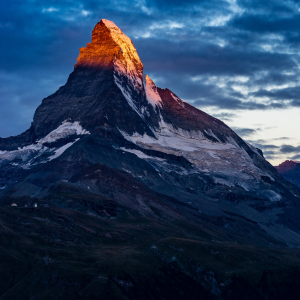 Bergmassiv, die Bergspitze leuchtet orangerot vom Sonnenlicht