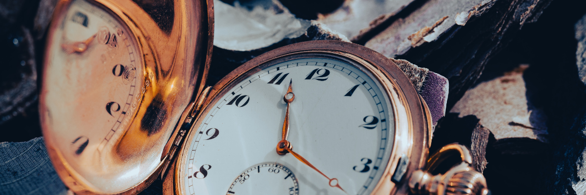 Nahaufnahme einer Taschenuhr, die auf dem Boden liegt