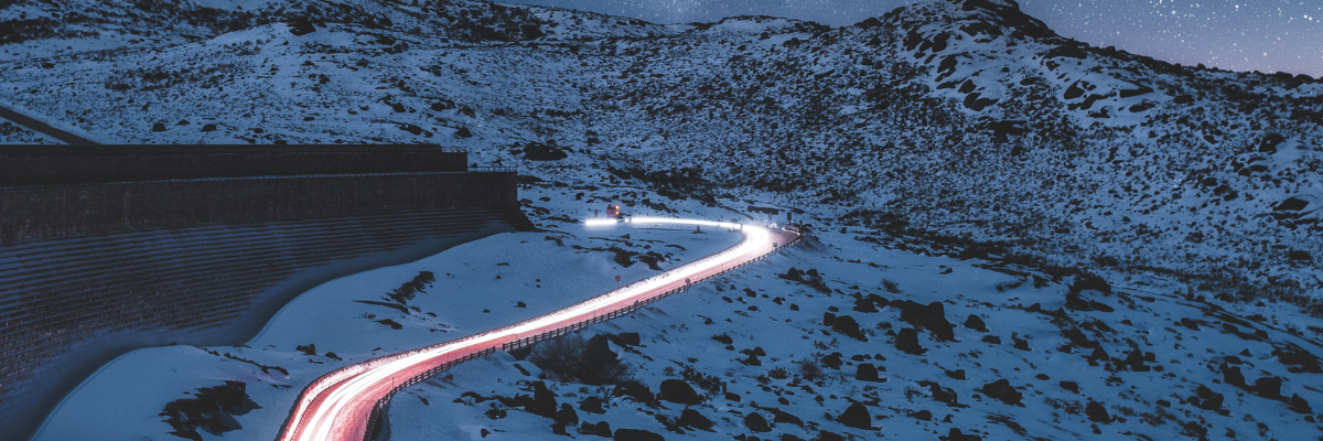 Nächtliche Zeitrafferaufnahme einer Straße im Schnee